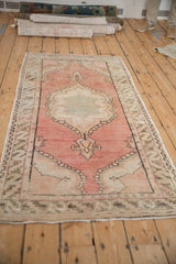 Distressed Oushak runner with blush, brown, ivory serrated leaf main border.
