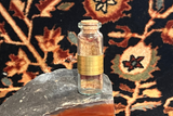 Antique silk rug fragment souvenir, hand-knotted and rolled inside a corked glass bottle.