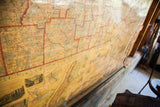 Angled view of the 1860 New York map's aged surface with red-lined counties.