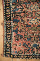 Floral palmettes and serrated leaves on the low, hand-knotted pile of an antique Lilihan rug.