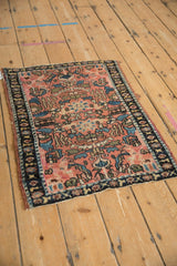 Angled perspective of an antique Lilihan rug showing floral palmettes on a dusty rose ground.