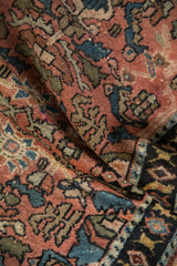 Draped folds of an antique Lilihan rug showing its textured pile and floral palmette designs.