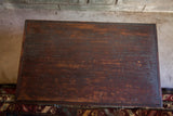 Antique wooden cabinet top with deep reddish-brown finish, natural grain, and aged texture.