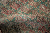 Kerman rug fold revealing worn jade green, raspberry Rococo botehs, foundation exposed.