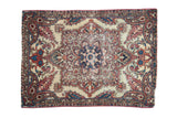 Antique Kerman rug fragment with a central medallion, boteh corners, and a red, blue, and orange palette.