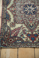 Corner spandrel of an antique Kerman rug with its intricate boteh paisley design and low-pile texture.