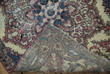 Folded corner of an antique Kerman rug reveals its woven foundation and cochineal red binding.