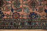 Antique Mehriban rug with dusty rose field, sapphire palmettes, serrated leaves, visible wear, frayed end.
