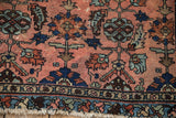 Antique Mehriban rug border shows dusty rose field, sapphire palmettes, serrated leaves, and worn fringe.