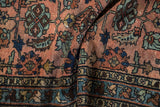 Folded antique Mehriban rug revealing dusty rose field, sapphire blue palmettes, and border patterns.