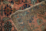 Antique Mehriban rug with worn dusty rose field, faded sapphire palmettes, tattered edge, visible foundation.