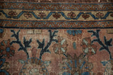 Worn dusty plum field and sapphire vinery near serrated border on antique Mehriban rug.