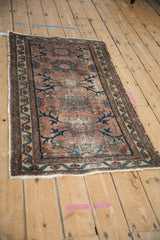 Close-up of antique Mehriban rug's faded plum, sapphire blue vinery, and exposed foundation wear.