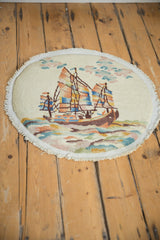 Colorful pictorial ship and ocean waves on Art Deco round rug's secured edge.