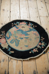 Securely finished edge of the antique Art Deco rug, showing black border and dusty rose florals.