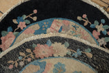 Hand-knotted construction, finished edge, and muted Art Deco colors of an antique round rug.