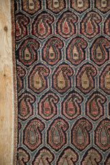 Farahan Sarouk rug fragment close-up, repeating boteh pattern in navy, red, teal, and beige.