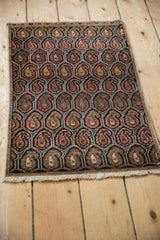 Repeating boteh pattern in navy, brick red, teal, and beige on a vintage Farahan Sarouk rug.