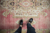 Distressed Kars carpet's short pile, abrashed field, with soft pink and dusty gold motifs.