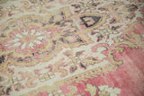 Distressed vintage Kars carpet pile with Rococo stylized floral motifs in pink, gold, and silver tones.
