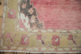 Distressed Kars carpet corner with dusty gold blossoming boteh border, raspberry field, and fringe.