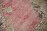 Distressed raspberry red field with soft abrash and floral patterned border.