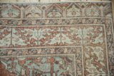 Distressed Turkish Sparta rug corner: terracotta, beige, dusty blue, meandering vine border, worn pile.