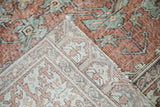 Distressed terracotta and dusty blue Sparta rug pile, folded to show its woven foundation.