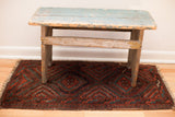 Tattered fringe and worn, rhythmic geometric pattern on this Balouch rug, with mallard green.