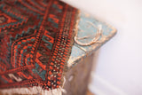 Mallard green and rust geometric pattern with aged fringe on a tribal Balouch rug.
