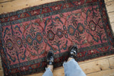 Antique Lilihan runner with dusty magenta field, showing palmette medallions and perched birds.