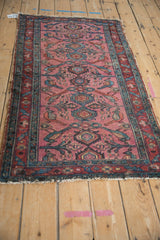 Antique Lilihan runner detail: dusty magenta field, teal palmettes, and perched birds.