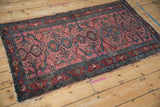 Dusty magenta field of an antique Lilihan runner showcasing palmettes, perched birds, and teal plants.