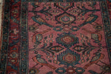 Antique Lilihan rug detail showing dusty magenta field, perched teal birds, and minor palmettes.