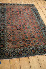 Antique Bibikabad rug's copper field featuring Veramin-inspired floral lattice and rich blue border.