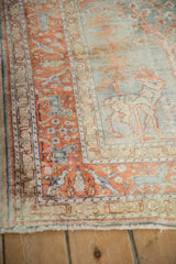 Close-up of vintage Kaisary rug with pictorial deer, terracotta animal border, and silver accents.