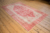 Distressed Oushak rug's ivory tree of life motifs and raspberry red border.