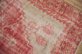 Distressed Oushak rug texture: raspberry red geometric blossoms and prominent foundation wear.