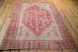 Corner detail of distressed vintage Oushak rug, showcasing worn texture and geometric border.