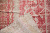 Distressed Oushak rug, with raspberry red pile wear, revealing hand-knotted reverse and machine-bound edge.