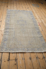 Distressed vintage Oushak rug: mostly even wear with foundation visible through ivory pile.
