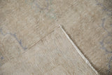 Distressed Oushak rug close-up: low antique ivory pile showing foundation, with machine-bound edge.