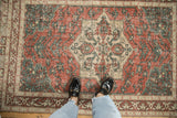 Styled view showing the scale of a vintage distressed Sparta rug in brick red and dusty teal.