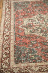 Mostly even wear on a vintage Sparta rug's low pile with brick red and dusty teal motifs.