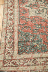 Low pile wear on a vintage Sparta rug highlights the brick red and dusty teal geometric motifs.