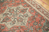 Worn texture on the starburst medallion and brick red field of a vintage hand-knotted Sparta rug.