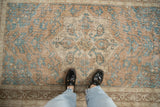 Distressed Sparta rug with ochre and turquoise geometric medallion and field motifs.