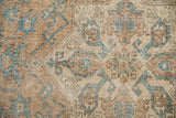 Hand-knotted Sparta rug showcasing distressed ochre pile with turquoise geometric blossom motifs.
