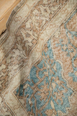 Worn pile texture of a distressed Vintage Sparta rug, with geometric beige and turquoise motifs.
