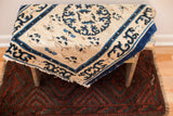 Tattered early Peking rug fragment, ivory field, bold blue medallion, pearl border. 1'7